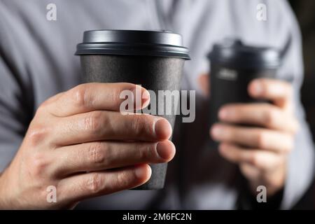 Cropped image of man holding two cups of take-out coffee, Stock Photo