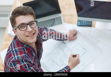 Architect working on drawing table in office Stock Photo