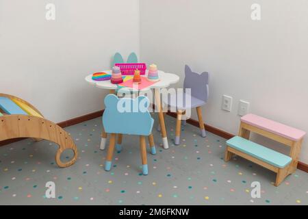 Children's area in pediatric office, with a table and chairs for children to draw. Stock Photo