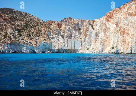 Vertical cliff wall and blue water of the aegean sea Stock Photo