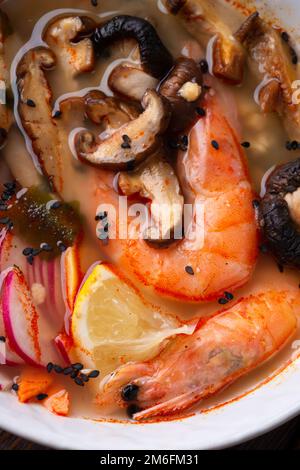 Miso soup with mussels, shrimps , shiitake mushrooms and vegatables. macro shot. flat lay Stock Photo