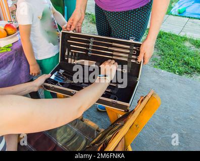 Two women look at a luxury barbecue set, in a gift box Stock Photo