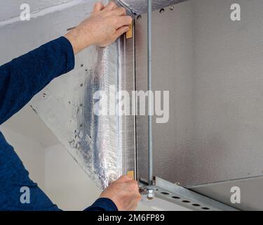 HVAC service technician changing dirty indoor air filter in residential heating and air conditioning system. Home air duct ventilation system maintena Stock Photo