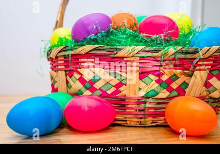 Wicker Easter basket with vintage colorful plastic Easter eggs. Stock Photo