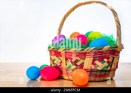 Wicker Easter basket with vintage colorful plastic Easter eggs. Stock Photo