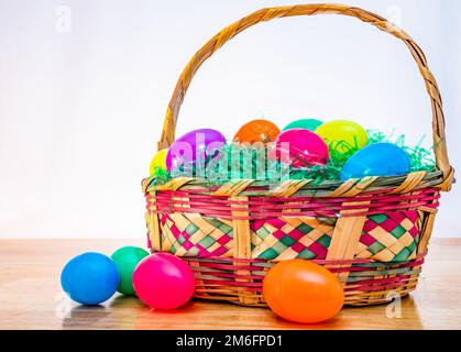 Woven Easter basket with vintage colorful plastic Easter eggs. Stock Photo