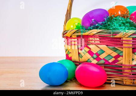 Wicker Easter basket with vintage colorful plastic Easter eggs. Stock Photo