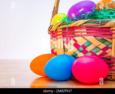 Wicker Easter basket with vintage colorful plastic Easter eggs. Stock Photo