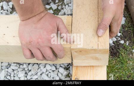 Close-up of rough male hands using new lumber for work, outdoors Stock Photo