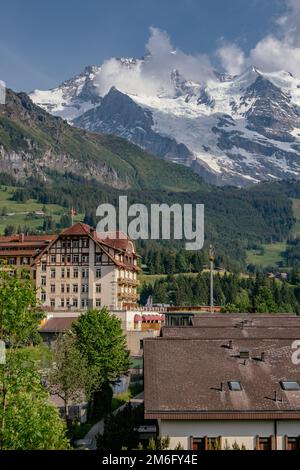 Aerial Panorama View with a Hotel Resort and Mountains in the Background - Jungfrau Region, Wengen, Switzerland Stock Photo