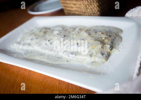 Vitello tonnato is a Piedmontese dish of sliced cold veal covered in a creamy mayonnaise-like sauce that has been flavored with tuna. Stock Photo