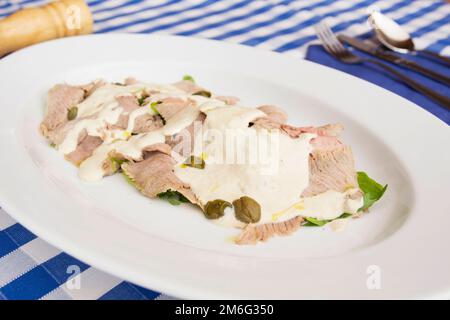 Vitello tonnato is a Piedmontese dish of sliced cold veal covered in a creamy mayonnaise-like sauce that has been flavored with tuna. Stock Photo