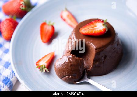 Chocolate panna cotta with strawberry pieces. Italian recipe Stock Photo