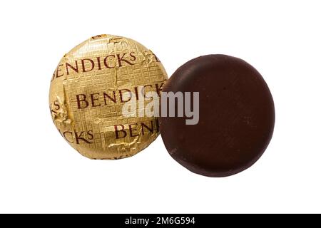 two Bendicks Mint Fondants, one unwrapped, isolated on white background - peppermint creams covered in rich dark chocolate Stock Photo