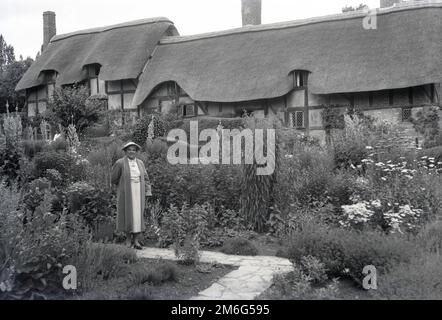 1950s, historcial, a lady visitor in the gardens of Anne Hathaway's cottage, a thatched farmhouse in Shottery, Warwickshire, England, UK. This was the childhood home of the wife of famous English playwright, William Shakespeare who was born in the nearby town of Stratford-Upon-Avon. Stock Photo