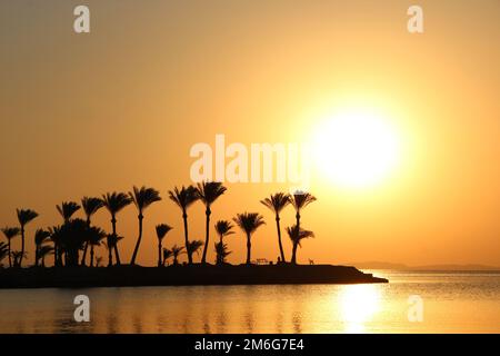 Beautiful place for privacy. Sunset over island in sea. Bright sun during dawn over the sea Stock Photo