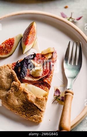 Homemade figs galette made with fresh organic figs, thyme, goats cheese on marble table Stock Photo