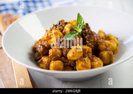 Gnocchi with red pesto sauce made with dried tomatoes. Stock Photo