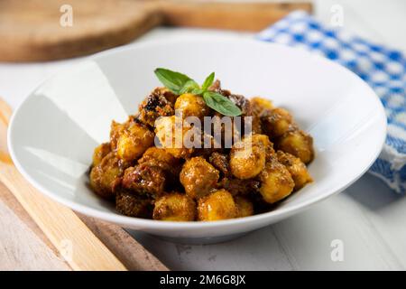 Gnocchi with red pesto sauce made with dried tomatoes. Stock Photo