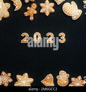 Cozy Christmas gingerbread set frame on a black background and the number 2023 in the Center. Top View. Christmas and a Happy New Year Concept. Square Stock Photo
