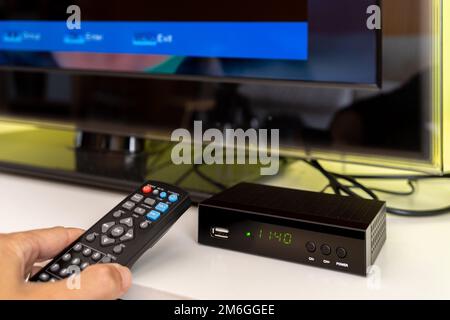 Digital decoder with remote control and television monitor. Stock Photo