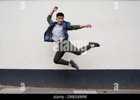 A young male asian dancer moves in a London street Stock Photo