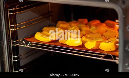 Pumpkin slices baked on a baking sheet in the oven. Homemade food Stock Photo