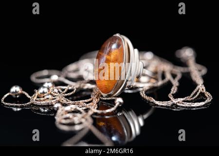 Elegant gold chain and gold ring with amber Stock Photo