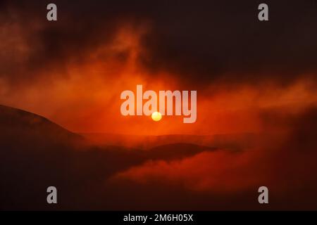 Mountain dramatic sunset in clouds Stock Photo