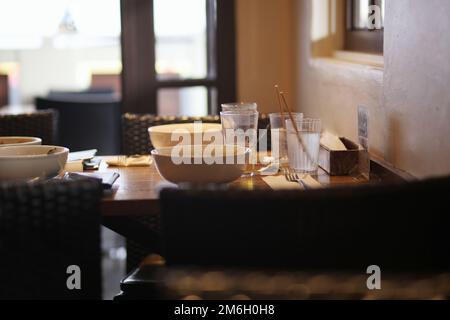 Restaurant tables with dirty dishes left in natural light Stock Photo