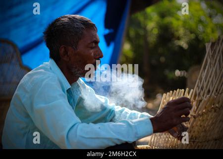 Vadodara, Gujarat - November 19th 2022: Aged Indian man close up face with wrinkled skin and grey hair good and beautiful face smoking Stock Photo