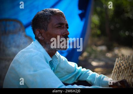 Vadodara, Gujarat - November 19th 2022: Aged Indian man close up face with wrinkled skin and grey hair good and beautiful face smoking Stock Photo