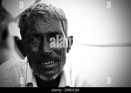 Vadodara, Gujarat - November 19th 2022: Aged Indian man close up face with wrinkled skin and grey hair good and beautiful face smoking Stock Photo