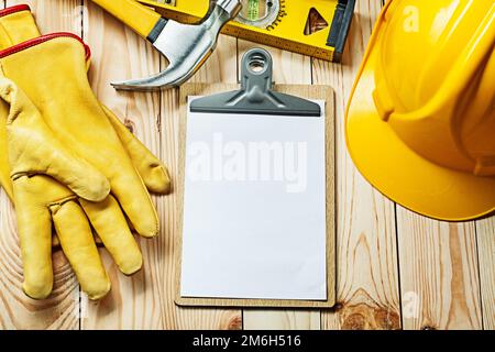 clipboard with white blank paper sheet  for your text gloves hammer level helmet Stock Photo