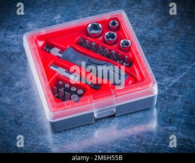 Closed toolbox with screwdriver and replaceable bits on metallic background construction concept. Stock Photo