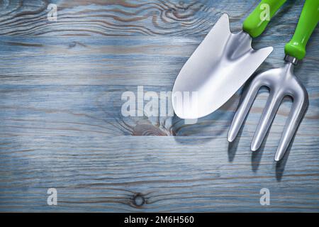 Hand spade trowel fork on wooden board gardening concept. Stock Photo