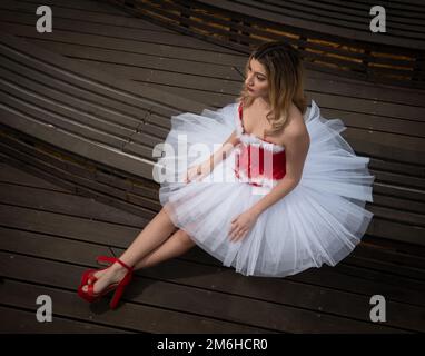 Ballerina wearing christmas white red dress posing on the floor Stock Photo