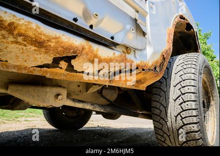 Fragment of a car body with rust. fragment of a rusty wing of a car. The body element is corroded. Concept: corrosion resistance Stock Photo