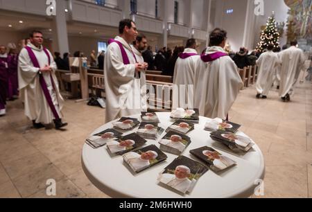 Stuttgart, Germany. 04th Jan, 2023. Numerous pictures of the emeritus and deceased Pope Benedict XVI, lie on a table in the entrance area of the Cathedral Church of St. Eberhard. Visitors celebrate a pontifical requiem for the deceased pope in the cathedral church.emeritus and deceased Pope Benedict XVI. Credit: Christoph Schmidt/dpa/Alamy Live News Stock Photo