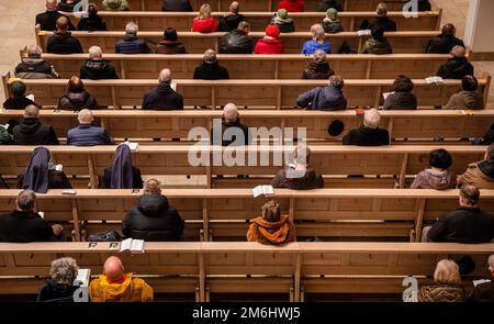 Stuttgart, Germany. 04th Jan, 2023. Visitors sit in the Cathedral Church of St. Eberhard to celebrate a pontifical requiem for Pope Emeritus Benedict XVI, who has died. Credit: Christoph Schmidt/dpa/Alamy Live News Stock Photo