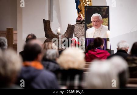 Stuttgart, Germany. 04th Jan, 2023. Visitors sit in the Cathedral Church of St. Eberhard to celebrate a pontifical requiem for Pope Emeritus Benedict XVI, who has died. Credit: Christoph Schmidt/dpa/Alamy Live News Stock Photo