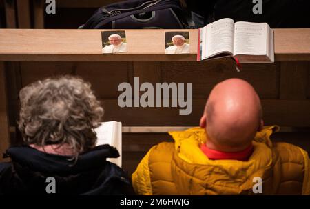 Stuttgart, Germany. 04th Jan, 2023. Visitors sit in the Cathedral Church of St. Eberhard to celebrate a pontifical requiem for Pope Emeritus Benedict XVI, who has died. Credit: Christoph Schmidt/dpa/Alamy Live News Stock Photo