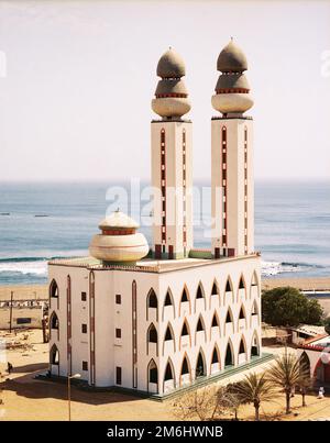 A vertical shot of the Grand Mosque of Dakar in Senegal with a seascape in the background Stock Photo