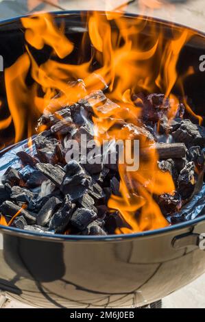 round BBQ with lit charcoal wood with flames Stock Photo - Alamy