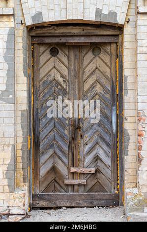 Weathered, old wooden door. Old rough and scratched wooden door. Front view. Close-up Stock Photo