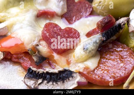 Heart shaped salami on a pizza Stock Photo