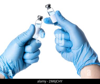 Hands in blue gloves holding two vaccine vials Stock Photo
