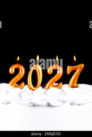 Golden candles write numbers flame Happy new year 2027 Stock Photo