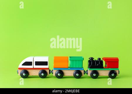 Train children toy, preschool kids game. Locomotive and carriages, wooden colorful blocks construction on green color background Stock Photo