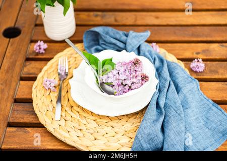 Spring place setting with lilac flowers on outdoor table Stock Photo ...